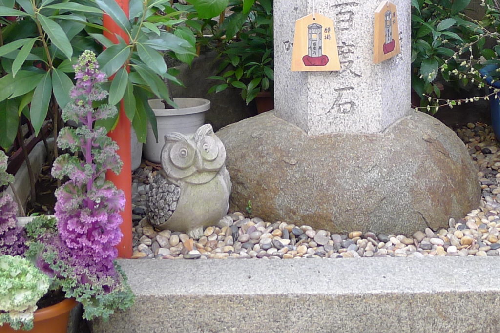 三崎稲荷神社の百度石の足元にいるフクロウ